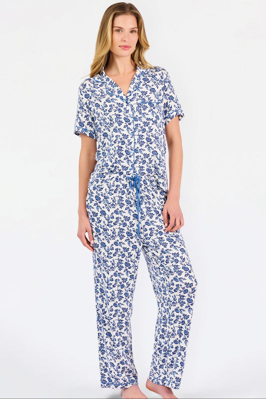 Woman wearing a blue floral pajama set on a white background
